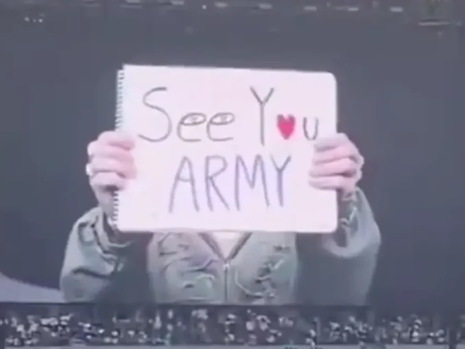 Jin de BTS brandit une pancarte "See You Army" à Paris